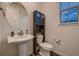 Stylish bathroom with pedestal sink and dark vanity at 9307 Inca Dove Cir, Littleton, CO 80125