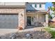 Two-story house with a gray garage door and brick accents at 5345 Goshawk St, Brighton, CO 80601