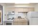 Small kitchen with white appliances and light-colored cabinetry at 1020 15Th St # 25F, Denver, CO 80202