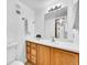 Clean bathroom with wood cabinets and a large vanity mirror at 14751 E Tennessee Dr # 225, Aurora, CO 80012