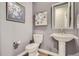 Stylish powder room with pedestal sink, toilet, and framed floral art at 7759 Piney River Ave, Littleton, CO 80125