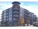 Modern multi-story condo building with blue accents and balconies at 1488 Madison St # 211, Denver, CO 80206