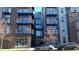 Front view of a multi-story building with blue balconies and brick exterior at 1488 Madison St # 211, Denver, CO 80206