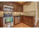 Modern kitchen featuring stainless steel appliances, dark wood cabinetry, and granite countertops at 1488 Madison St # 211, Denver, CO 80206