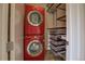 Laundry room with red front-loading washer and dryer, and built-in shelving at 1488 Madison St # 211, Denver, CO 80206