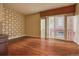 Living room with wood floors, geometric wall, and sliding glass doors to a balcony at 1488 Madison St # 211, Denver, CO 80206