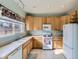 Oak kitchen cabinets, white appliances and a tiled floor at 4936 Stoneham Ave, Castle Rock, CO 80104