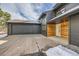 Two-car garage and entryway with modern wood and gray siding at 1298 Silverheels Dr, Larkspur, CO 80118