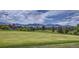 Scenic view of a golf course with mountains in the background at 14585 W 91St Ave # A, Arvada, CO 80005