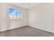 Simple bedroom with carpet, window, and neutral-colored walls at 5241 S Shawnee St, Aurora, CO 80015