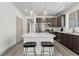 Kitchen island with white quartz countertop and dark wood cabinets at 18633 Stroh Rd # 1-106, Parker, CO 80134