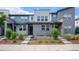 Modern townhome exterior with gray and teal siding, landscaping, and walkway at 16231 E Warner Pl, Denver, CO 80239