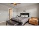 Bright bedroom with a queen bed, an armchair, and access to a full bathroom at 16231 E Warner Pl, Denver, CO 80239