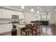Modern kitchen with white cabinets, granite countertops, and an island with seating at 16231 E Warner Pl, Denver, CO 80239