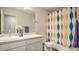 Bathroom with single sink, bathtub, and colorful shower curtain at 16231 E Warner Pl, Denver, CO 80239