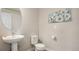Clean bathroom with pedestal sink, toilet, and framed wall art at 16231 E Warner Pl, Denver, CO 80239