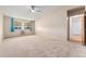 Large carpeted bedroom with ceiling fan and window, access to bathroom and closet at 650 S Alton Way # 5D, Denver, CO 80247