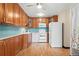 Bright kitchen with wood cabinets, white appliances, and light blue tile backsplash at 650 S Alton Way # 5D, Denver, CO 80247