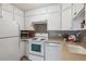White kitchen with stainless steel appliances at 690 S Alton Way # 1C, Denver, CO 80247