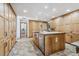 Bright kitchen with a large island, custom cabinetry, and tile flooring at 3081 W 151St Ct, Broomfield, CO 80023