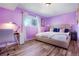 Spacious bedroom with purple walls, wood floors, and a king-size bed at 7525 W 62Nd Ave # 11, Arvada, CO 80003