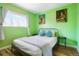 Green bedroom with a queen bed, artwork, and wood floors at 7525 W 62Nd Ave # 11, Arvada, CO 80003