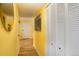 Bright yellow hallway with wood floors, mirrored wall art, and built-in storage at 7525 W 62Nd Ave # 11, Arvada, CO 80003