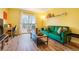 Living room with green couch, wood floors, and access to a balcony at 7525 W 62Nd Ave # 11, Arvada, CO 80003