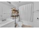 Clean bathroom with a shower/tub combo and shelving unit at 2160 S Vaughn Way # 304C, Aurora, CO 80014