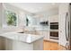 U-shaped kitchen with white cabinets, stainless steel appliances, and quartz countertops at 8154 Lone Maple Ln, Lone Tree, CO 80124