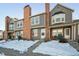 Gray townhouse exterior with brick accents and snowy landscaping at 17138 E Whitaker Dr # C, Aurora, CO 80015