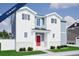 Two-story home with white and gray siding, red door, and a landscaped lawn at , Aurora, CO 80019