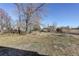 Spacious backyard with mature trees and a partially visible home at 3601 Sunrise Ln, Brighton, CO 80603