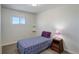 Small bedroom with a single bed, nightstand, and window at 3601 Sunrise Ln, Brighton, CO 80603
