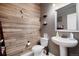 Stylish bathroom with wood-look wall and pedestal sink at 42395 Forest Oaks Dr, Elizabeth, CO 80107
