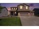 Two-story home with attached garage, illuminated at dusk at 42395 Forest Oaks Dr, Elizabeth, CO 80107