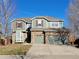 Two-story house with a green exterior, brown accents, and a three-car garage at 1563 Baguette Dr, Castle Rock, CO 80108