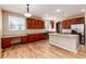 Kitchen boasts an island, ample cabinetry, and hardwood floors at 22264 E Frost Pl, Aurora, CO 80016