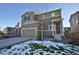 Two-story house with a green exterior, two-car garage, and snowy front yard at 1908 Homestead Dr, Fort Lupton, CO 80621