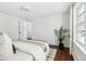 Serene bedroom with hardwood floors, a bed with neutral linens, and a large window at 1166 Kearney St, Denver, CO 80220