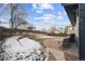 Backyard with patio and partial snow coverage at 9790 Moss Rose Cir, Highlands Ranch, CO 80129