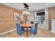 Cozy dining area with a wood table and blue chairs, featuring wood accent wall at 17128 E Jefferson Ave, Aurora, CO 80013