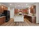 Spacious kitchen with dark wood cabinets, island, and black appliances at 863 Laramie Ln, Erie, CO 80516