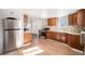 Kitchen features wood cabinets, tile backsplash, and stainless steel appliances at 2801 W Dartmouth Ave, Denver, CO 80236