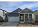 Gray exterior of charming craftsman style home with covered porch and 2-car garage at 498 Grey Rock St, Brighton, CO 80601