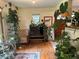Living room with a vintage chair, flat screen TV, and many plants at 106 Brook Rd, Evergreen, CO 80439