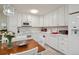 White kitchen with updated appliances and dining area at 9340 E Center Ave # 2C, Denver, CO 80247