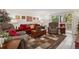 Relaxing living room featuring a red couch, two armchairs, and access to a balcony at 9340 E Center Ave # 2C, Denver, CO 80247