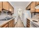 View of galley kitchen with wood cabinets and stainless steel appliances at 14904 E Hampden Cir # C7, Aurora, CO 80014