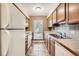 Galley kitchen with wood cabinets and stainless steel appliances at 14904 E Hampden Cir # C7, Aurora, CO 80014